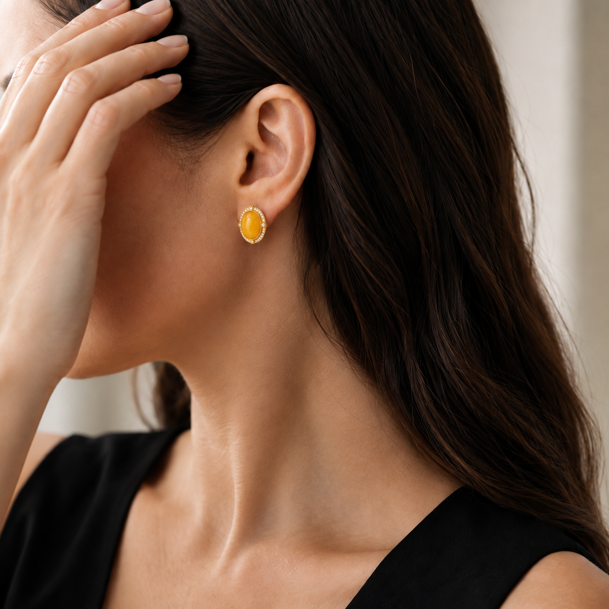 Natural amber stud earring styled with a black dress on a model