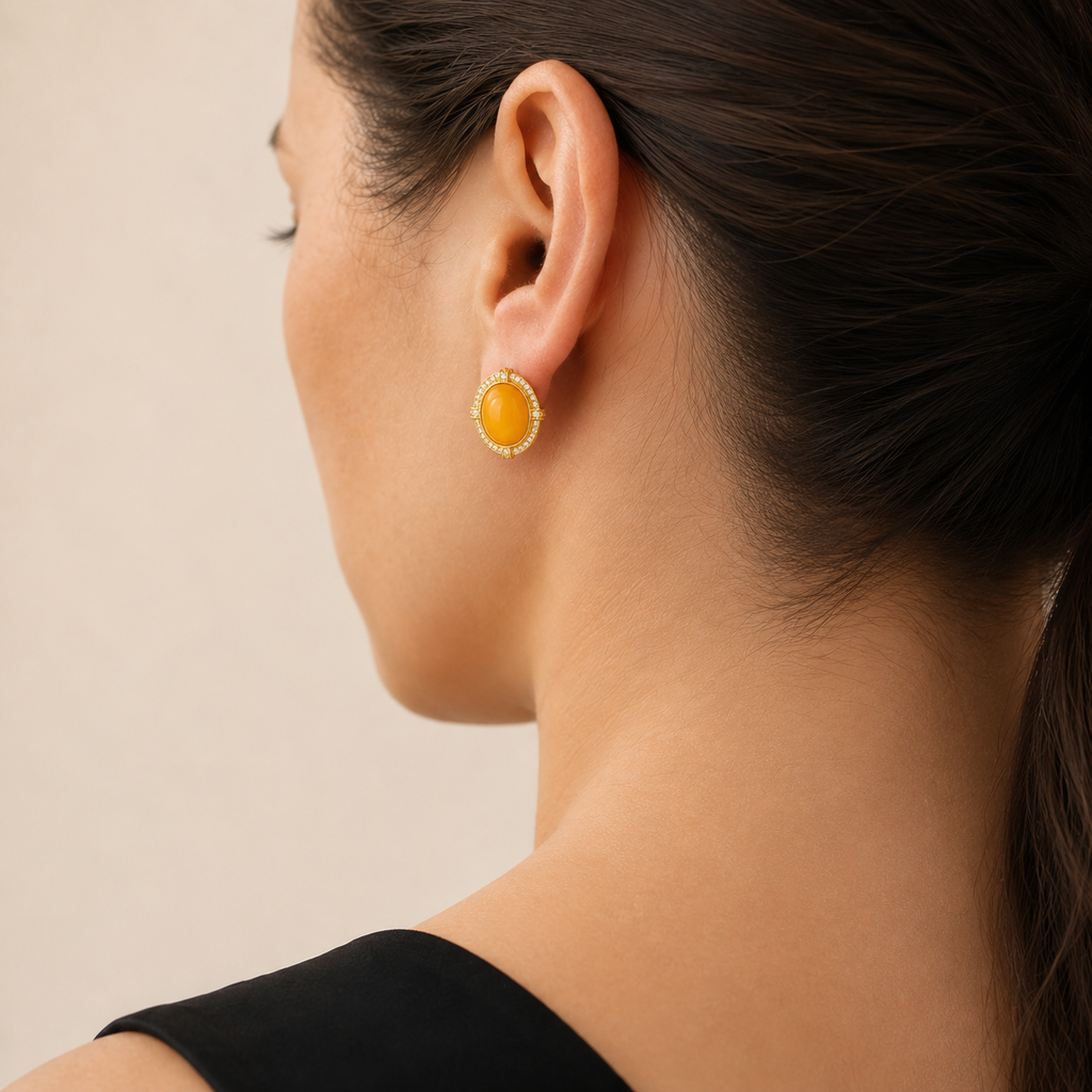 Natural amber stud earring worn on a model, rear three-quarter view