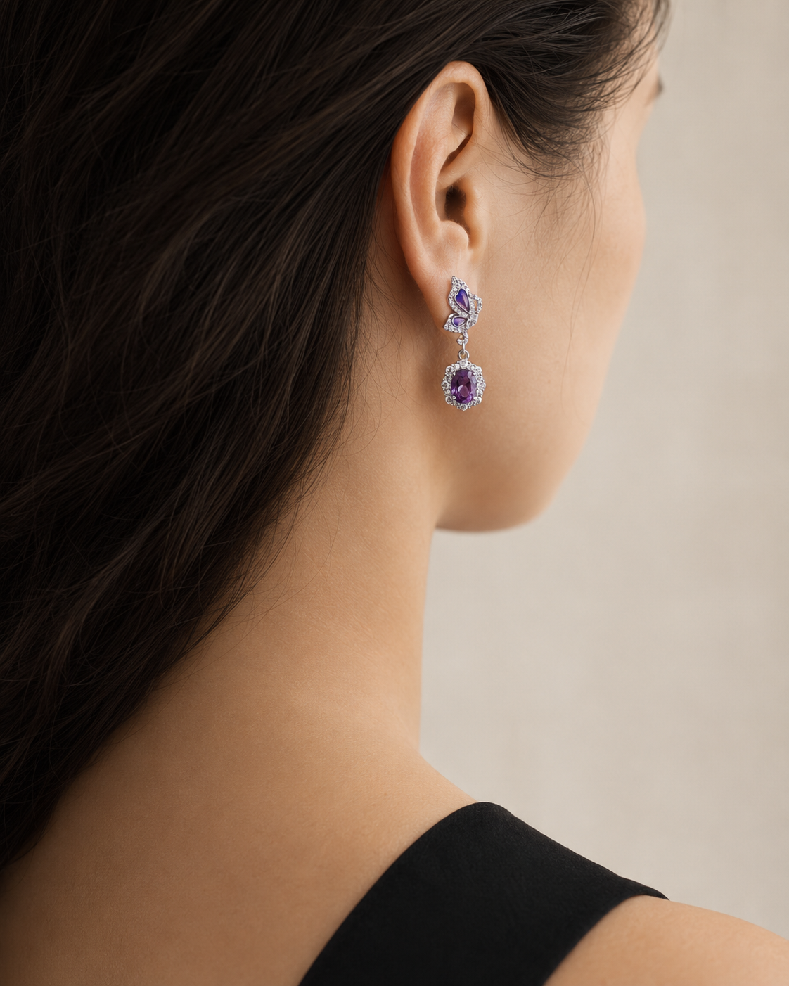 Amethyst butterfly dangle earring worn on a model, rear three-quarter view