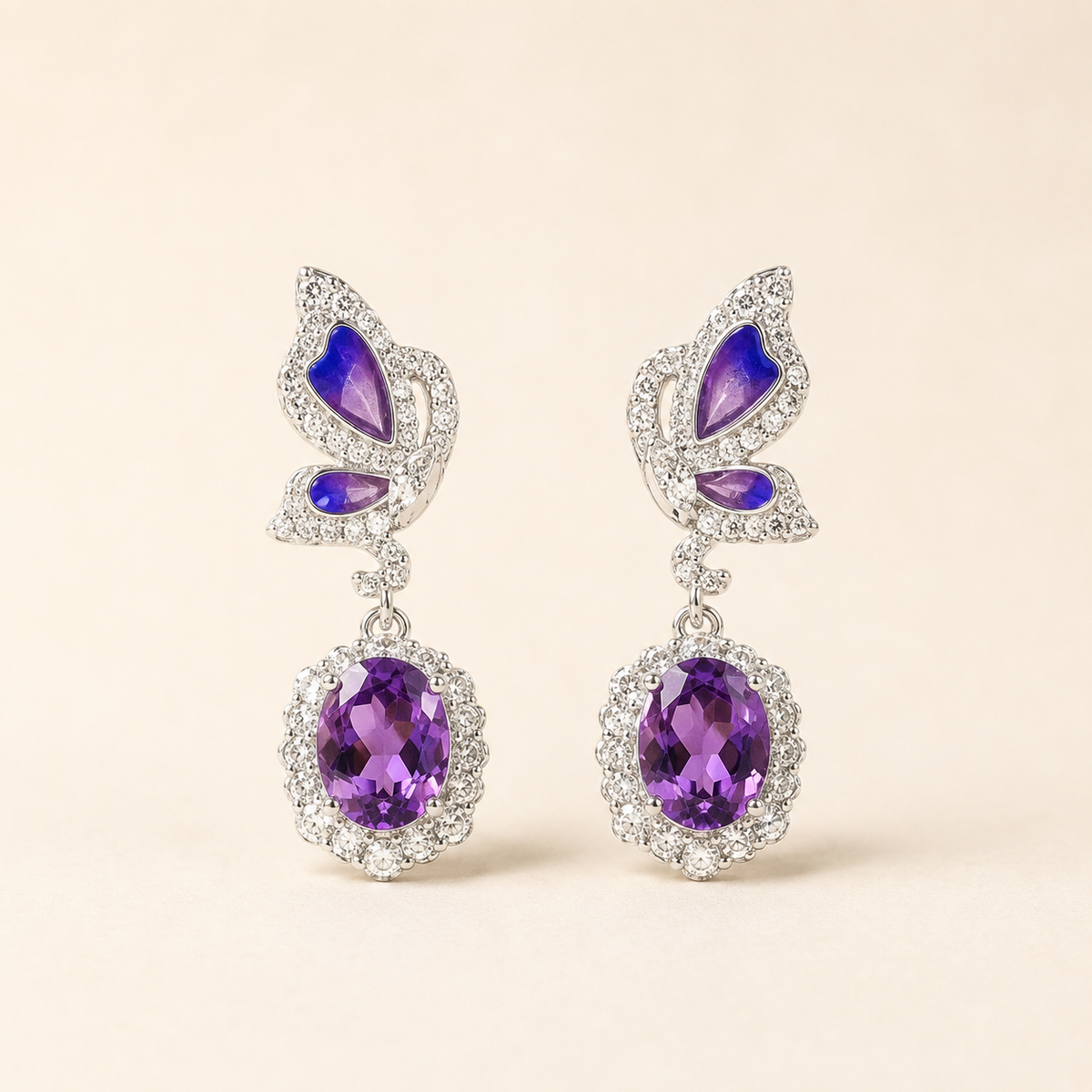 Amethyst butterfly dangle earrings on a warm ivory background