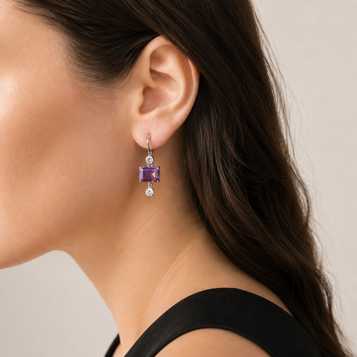 Natural amethyst drop hoop earring worn on a model, side view