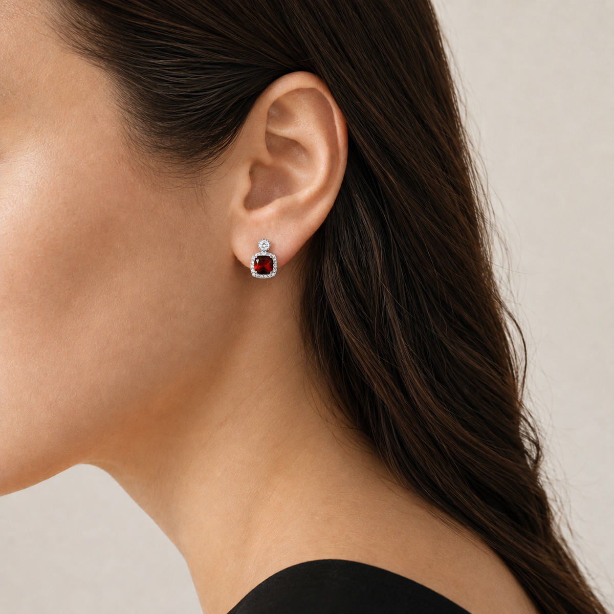 Natural garnet halo stud earring worn on a model, side view