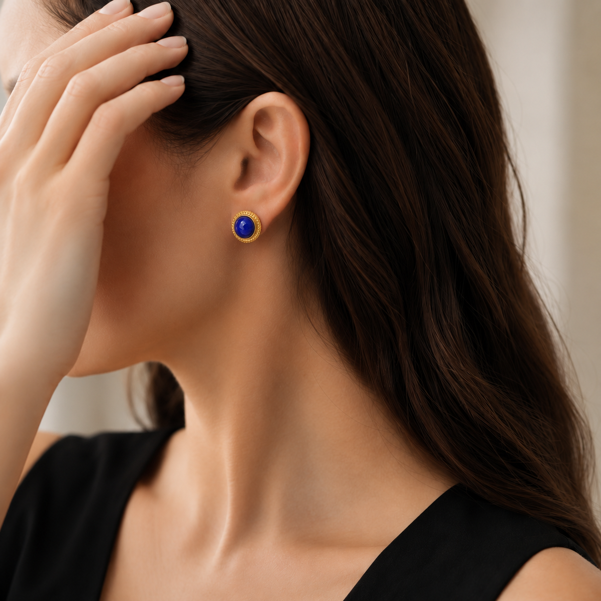 Natural lapis lazuli stud earring styled with a black dress on a model