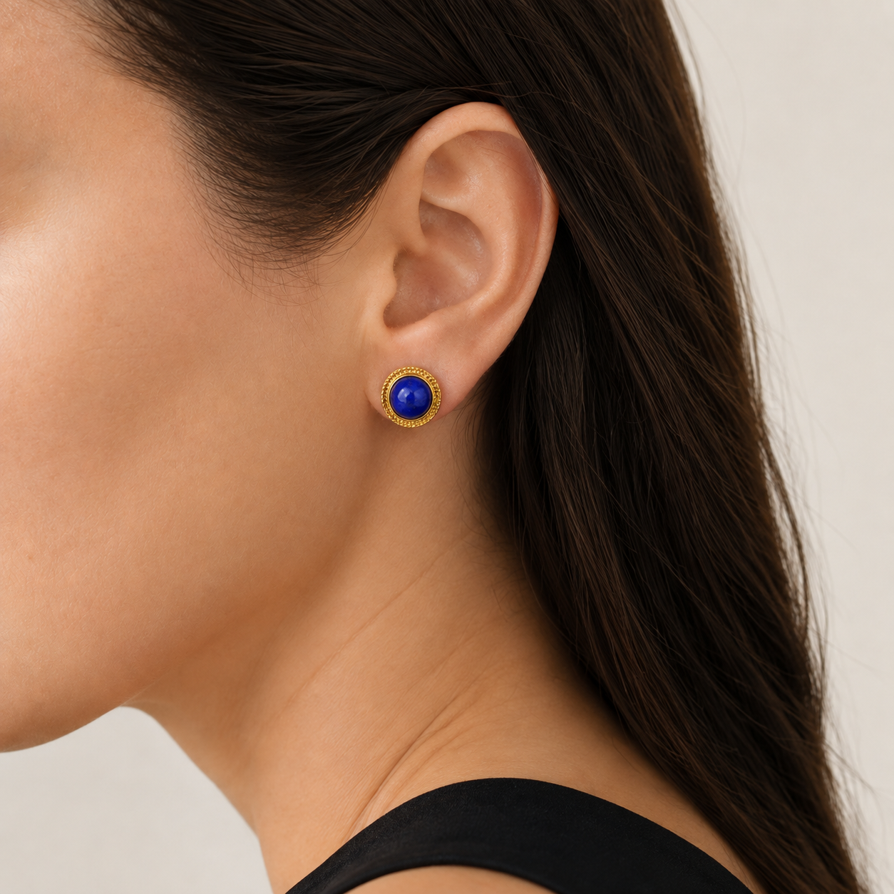 Natural lapis lazuli stud earring worn on a model, side view