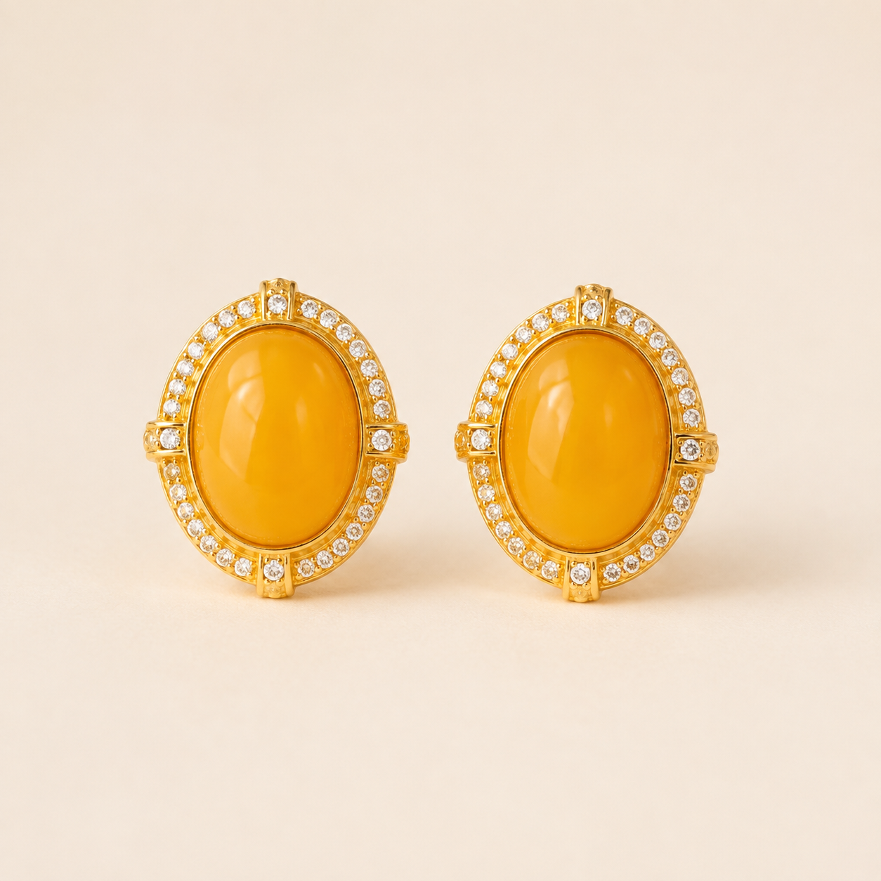 Natural amber stud earrings on a warm ivory background